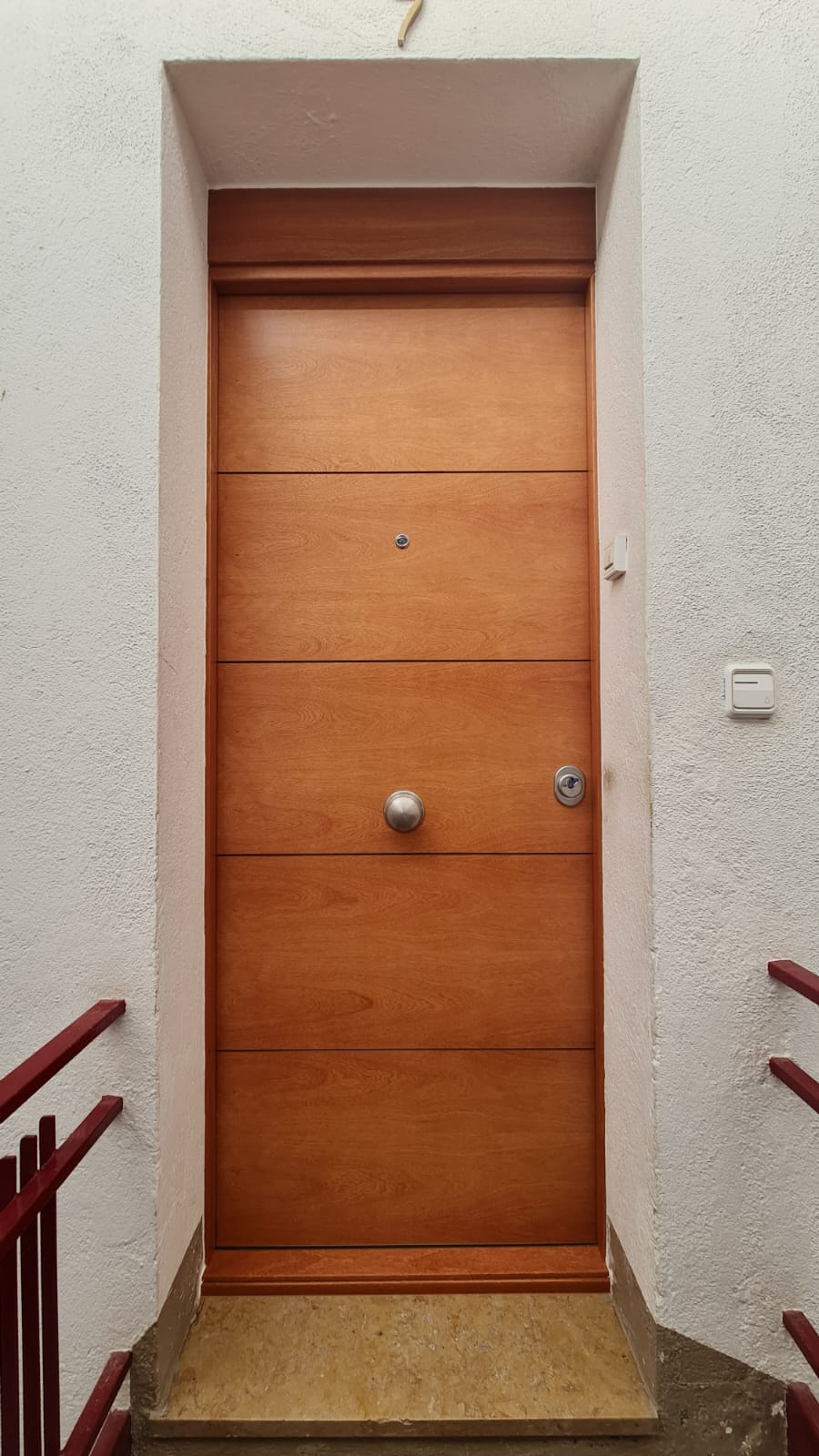 Puerta SegureStil en acabado madera en portal de comunidad